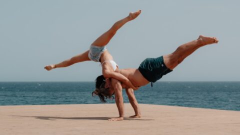 man in red shorts jumping on beach during daytime