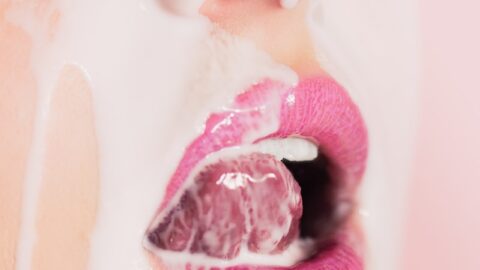 a close up of a woman's face with pink lipstick