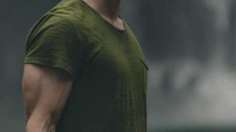 man wearing green crew-neck t-shirt looking upwards