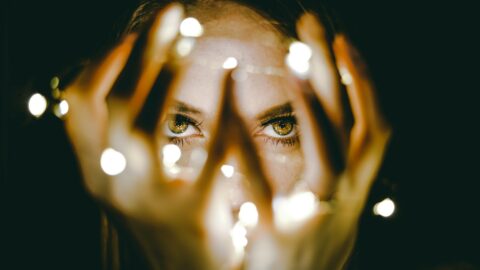 woman holding string lights