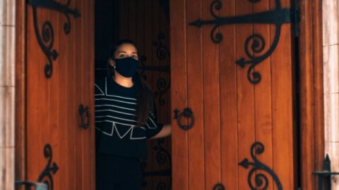 a woman standing in front of a wooden door